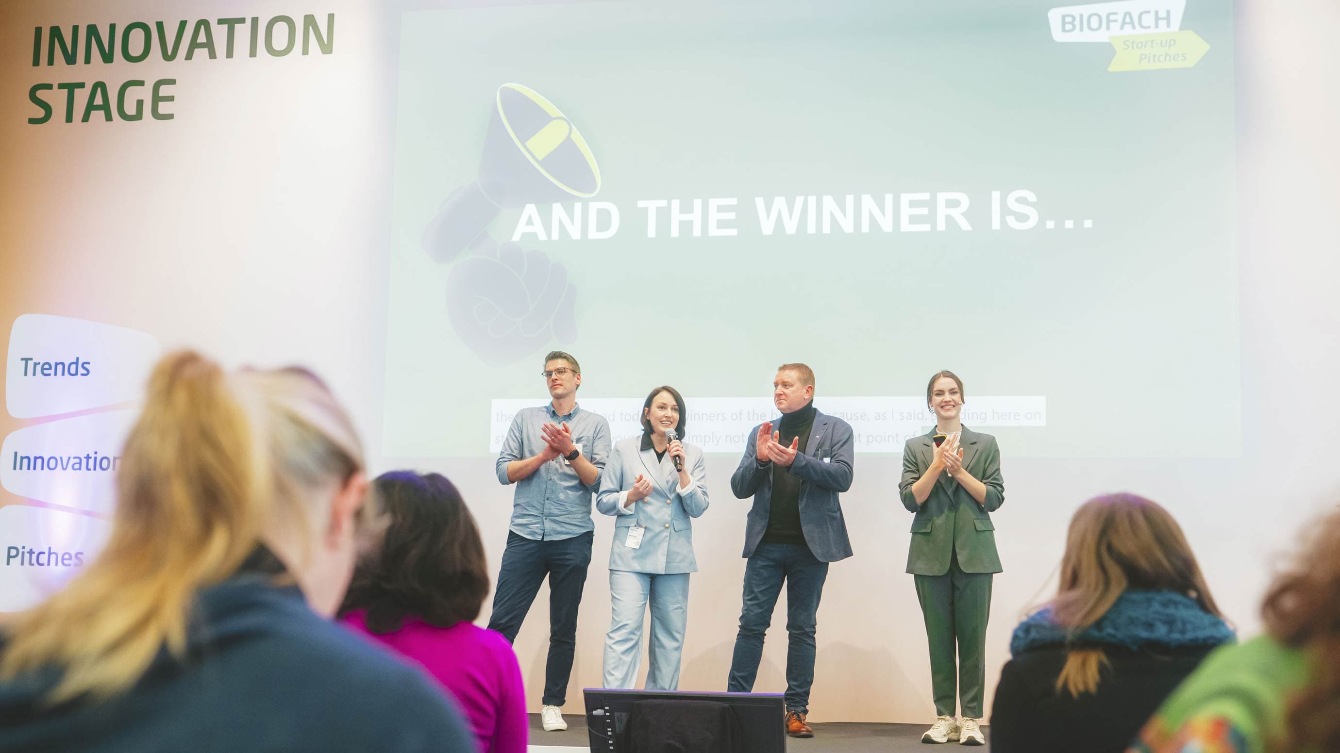 Four people applaud during an award ceremony on the INNOVATION STAGE