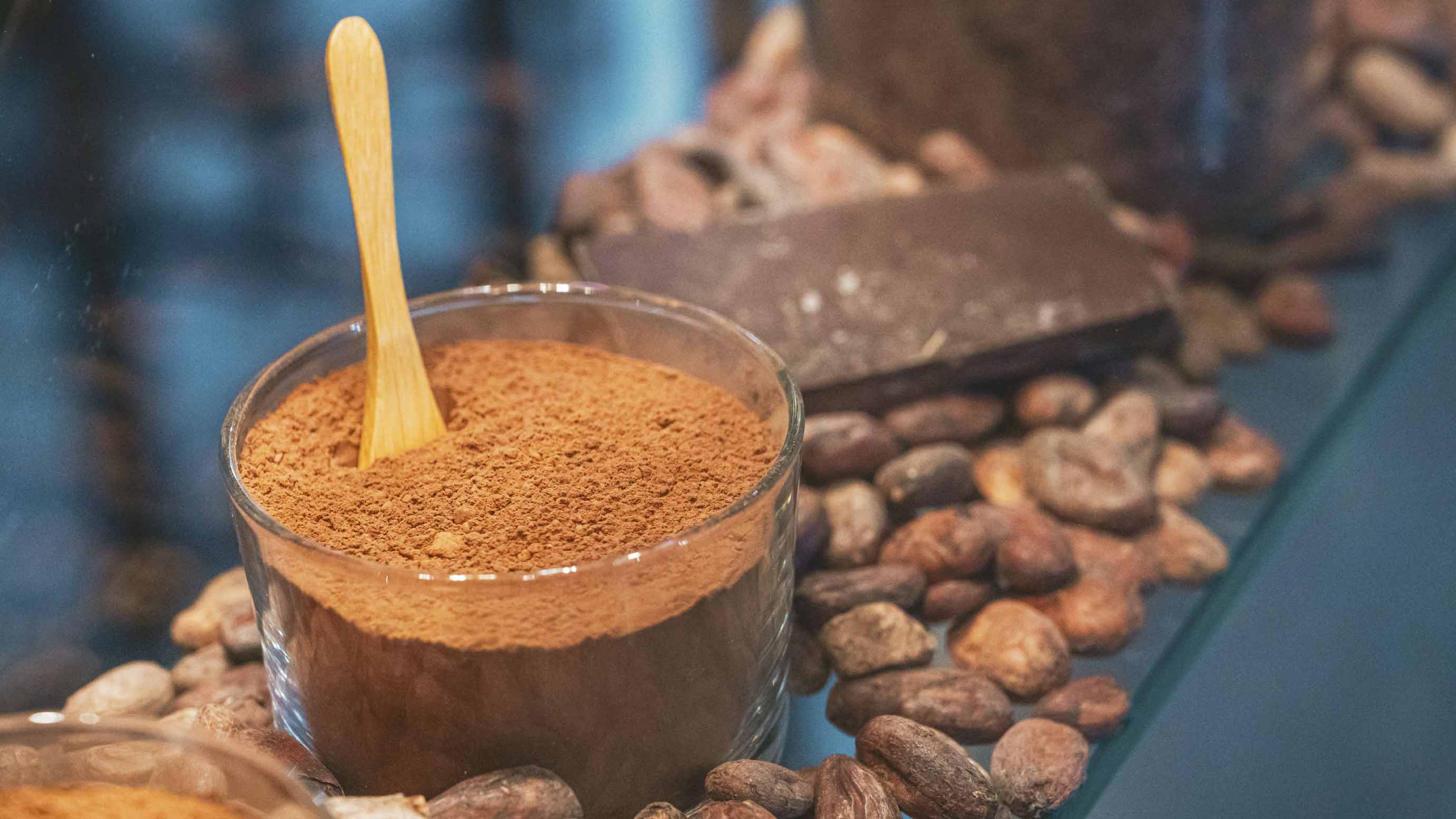 Cocoa powder and chocolate arranged on a wooden board, decorated with individual cocoa beans