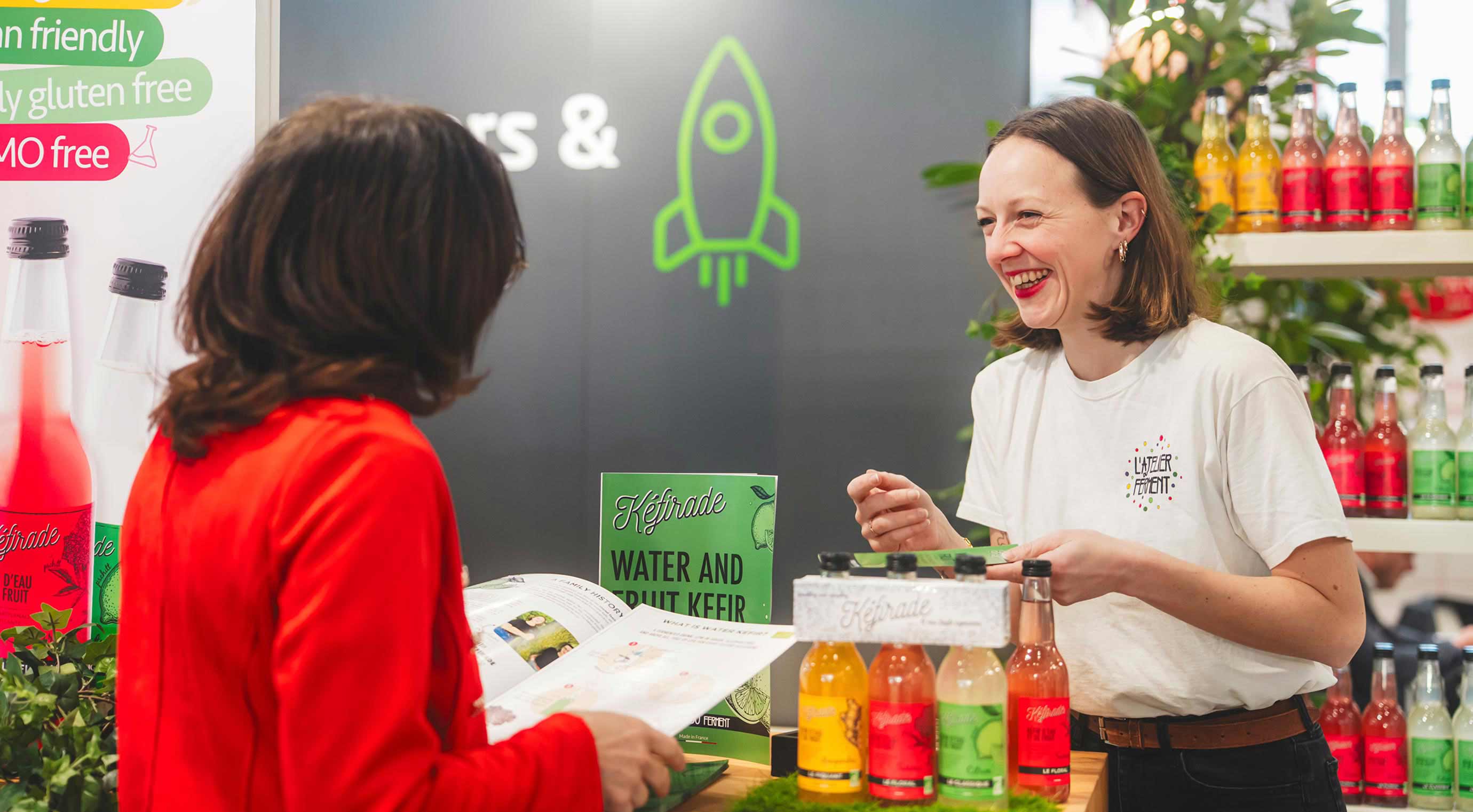 Two women in conversation at the stand of the International Start-Ups & Newcomer Area