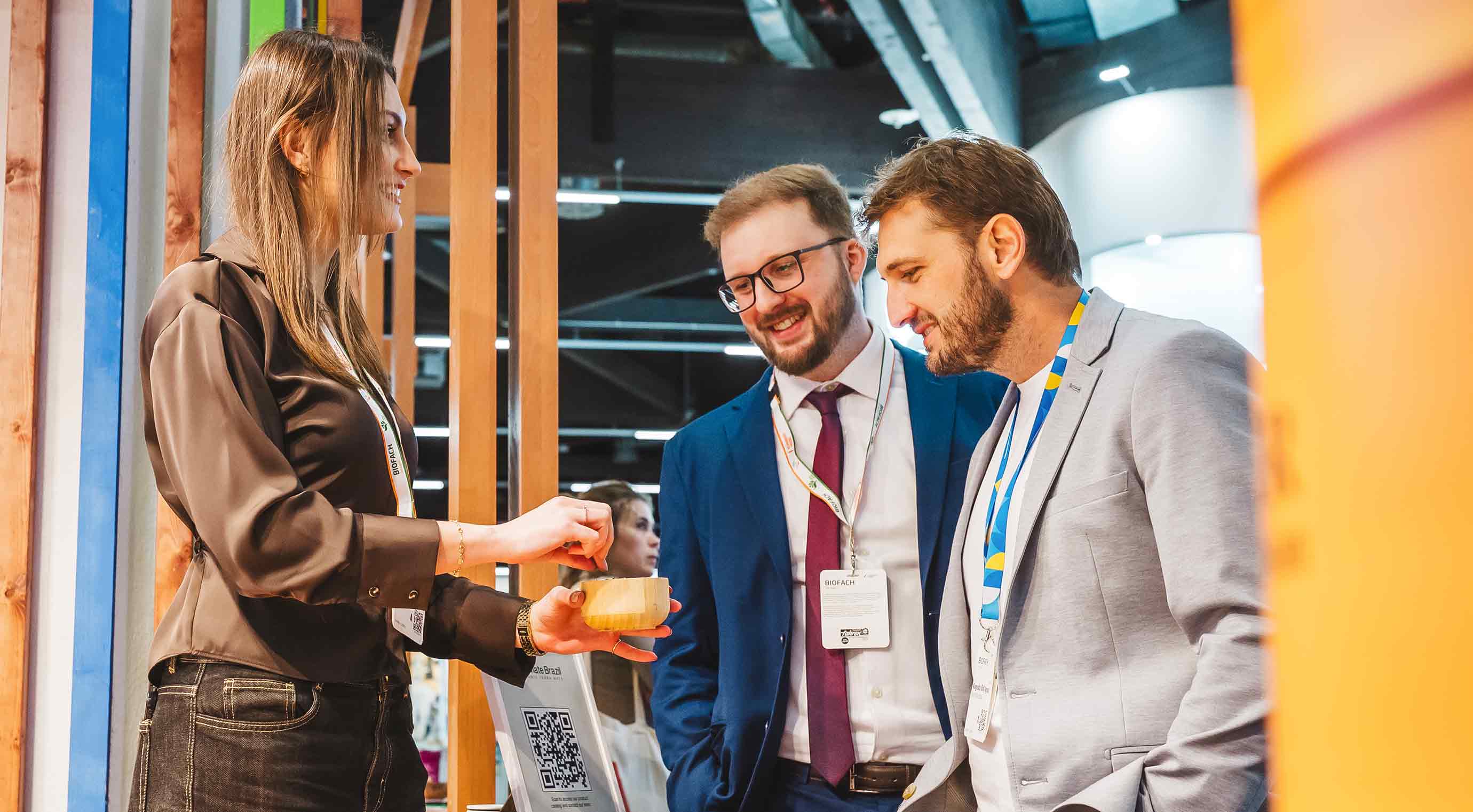 Two visitors at an exhibitor's booth during product tasting